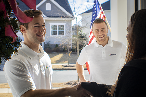 American Junk Removal crew greeting a customer at the door before mattress removal services